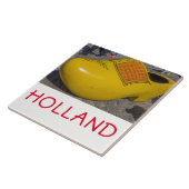 Hollandse houten klomp omhoog dichtbij keramische tegeltje (Zijkant)