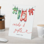 Holly Christmas Santa Baby shower Kaarten en cadea Reclamebord Met Voetstuk<br><div class="desc">Begeleid uw gasten met stijl met behulp van onze Holly Christmas Santa Baby shower Kaarten & Gifts Poster. Met een feestelijk Santa Claus-ontwerp met hulst- en wintergroen op een levendige rode achtergrond, leidt dit poster gasten naar de cadeautafel en het kaartstation. Het is een elegante toevoeging aan uw baby shower,...</div>