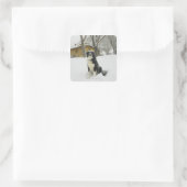 Hond zit in sneeuw, achter met een blokhut vierkante sticker (Tas)