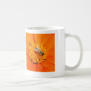 honingbij op de mok van oranje bloemen