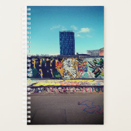Hoogbouw, achter een graffitimuur planner