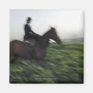 Horseback rijden op groen veld. Vrouwelijke horseb Magneet