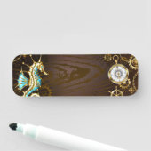 Houten achtergrond met mechanisch zeepaardje naamplaatje (In situ)