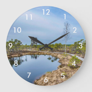 Houten spoor over moeras met toren grote klok
