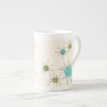 Iconic Atomic Starbursts Bone China Mok<br><div class="desc">Deze Iconische atoomstoot barst het Bone China Mok patroon met iconische atomaire sterrenbursts. Dat klopt! De oude school, crèmekleurige achtergrond met gouden spugen is de perfecte achtergrond voor de levendige turquoise, het kalkselderij en kitschy peren groene cirkels. De vlekken van kleur worden sporadisch geplaatst in diverse grootte met het bekleden...</div>