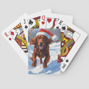 Ierse Rode Setter Rent Door Sneeuw met Kerstmuts Pokerkaarten