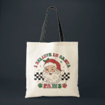 Ik geloof in Santa Paws Retro Christmas Hondenlief Tote Bag<br><div class="desc">I Believe In Santa Paws Retro Christmas Hondenliefhebber Festive Holiday Canvas tas bevat de tekst "I Believe In Santa Paws" in de moderne scripttypografie rond een vrolijke retro-kerstman op een zwart-witte dambordachtergrond geaccentueerd met pootafdrukken. Perfect voor kerstcadeaus,  kerstfeesten en vakantiefeesten,  verjaardagen en meer. Creëer door Evco Studio www.zazzle.com/store/evcostudio</div>