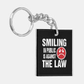 In het openbaar glimlachen is tegen de wet sleutelhanger (Voorkant Links)