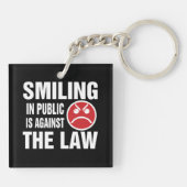 In het openbaar glimlachen is tegen de wet sleutelhanger (Achterkant)