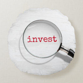 Investeertekst onder vergrootglas rond kussen