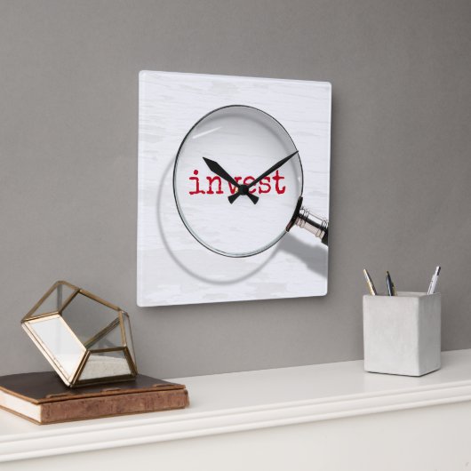 Investeertekst onder vergrootglas vierkante klok (Kantoor)
