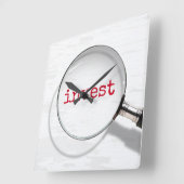 Investeertekst onder vergrootglas vierkante klok (Hoek)