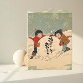 Japanse kinderen rollen een grote sneeuwbal kaart