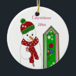 Jolly Snowman en Bird House Keramisch Ornament<br><div class="desc">Een joleus sneeuwman in een groen en rood pet en sjaal. Hij heeft een snoepriet. Een feestelijk vogelhuis met een kleine blauwe vogel op de baard. Pas het jaar aan of wijzig het bericht naar wens.</div>