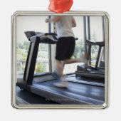 Jong man dat op een loopband in de gezondheidsclub metalen ornament (Voorkant)