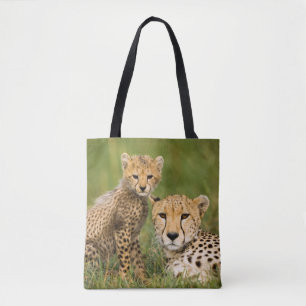 Jonge jachtluipaard en ouder in het gras tote bag