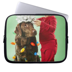 Jonge jongen die kerstverlichting rond een hond wi laptop sleeve