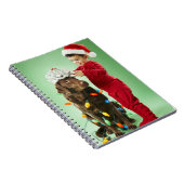 Jonge jongen die kerstverlichting rond een hond wi notitieboek (Rechterzijde)