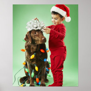 Jonge jongen die kerstverlichting rond een hond wi poster