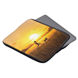 Jonge jongen loopt met hond bij zonsondergang laptop sleeve