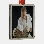 Jonge mannen breekborden met karaatklap op metalen ornament (Rechts)