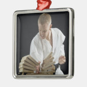 Jonge mannen breekborden met karaatklap op metalen ornament (Links)