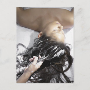 Jonge vrouw die een haarbehandeling krijgt briefkaart