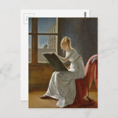 Jonge vrouw die naast een raam tekent briefkaart (Voorkant / Achterkant)