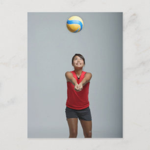 Jonge vrouw die volleybal speelt briefkaart