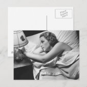 Jonge vrouw liggend op bed die lamp afzetten briefkaart (Voorkant / Achterkant)