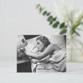 Jonge vrouw liggend op bed die lamp afzetten briefkaart (Staand voorkant)