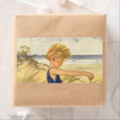  jongen die aan de strand met zandspeelgoed speelt etiket (Insitu)