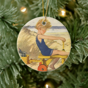 jongen die aan de strand met zandspeelgoed speelt keramisch ornament