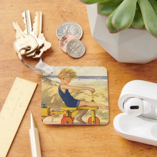  jongen die aan de strand met zandspeelgoed speelt sleutelhanger (Bureau)