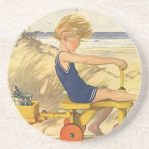 jongen die aan de strand met zandspeelgoed speelt zandsteen onderzetter