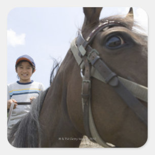 Jongen die op een paard rijden vierkante sticker
