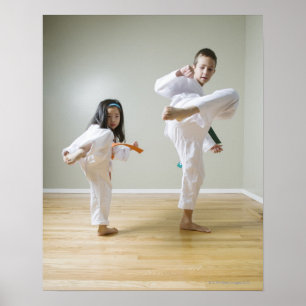 Jongen en meisjes (4-9) die Taekwondo-kicks oefene Poster