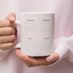 Kalender 2025 Mok | Zacht pastelroze |<br><div class="desc">Geniet van uw favoriete drankjes tijdens uw verblijf met deze 2025-kalender mok in een zacht pastelroze ontwerp. Deze mok combineert functionaliteit en elegantie en beschikt over een jaarkalender die ideaal is voor snelle datumverwijzingen. De zachte pastelroze tint voegt een vleugje sophisticatie toe, waardoor het een ideale keuze is voor uw...</div>
