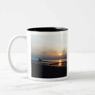 Kameel op het strand bij zonsondergang tweekleurige koffiemok
