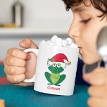 Kant-en-kerstkikker, speciaal voor kinderen koffiemok<br><div class="desc">Vrolijk kerstkikker in schattig pet voor de kerstman met gordels en mistletoe. Dit leuke cadeau voor de mok van vakantiedieren met een glimlachend groen kikkervisje maakt me gelukkig en vol kerstjuf.</div>