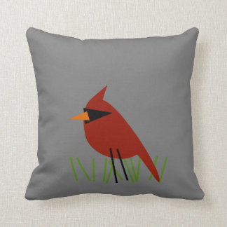 Kardinaal op gras met grijs kussen