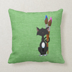 Kat met verfpenselen op groen kussen