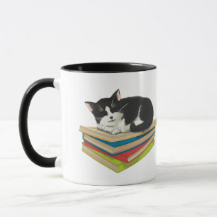 Kat slaapt op boeken mok