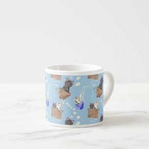 Katten in doos en melkdruppels op blauw espresso kop