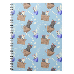 Katten in doos en melkdruppels op blauw notitieboek