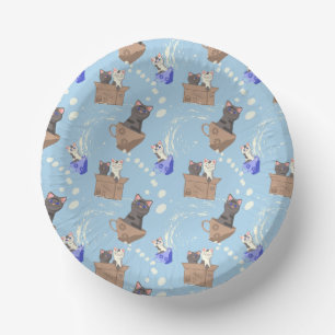 Katten in doos en melkdruppels op blauw papieren kommen