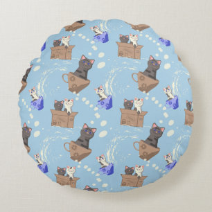 Katten in doos en melkdruppels op blauw rond kussen