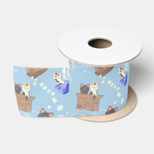 Katten in doos en melkdruppels op blauw satijnen lint