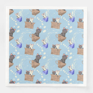 Katten in doos en melkdruppels op blauw servet
