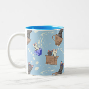 Katten in doos en melkdruppels op blauw tweekleurige koffiemok